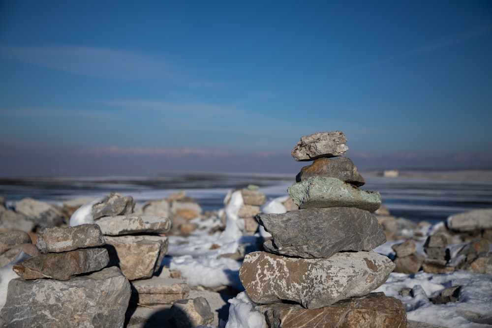 a pile of rocks sitting on top of snow covered ground