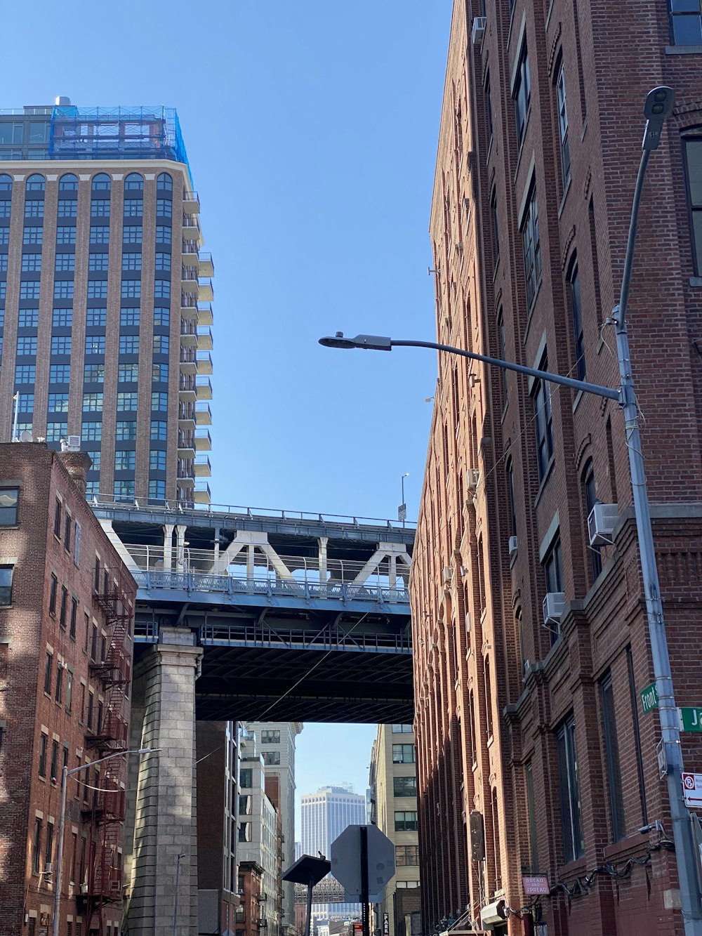a bridge over a city street next to tall buildings