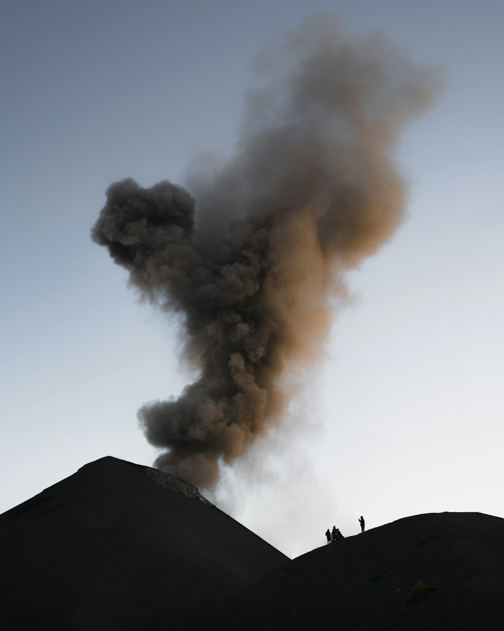 smoke billows from the top of a hill