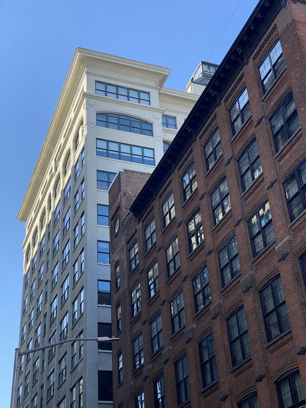 a tall building with lots of windows next to other buildings