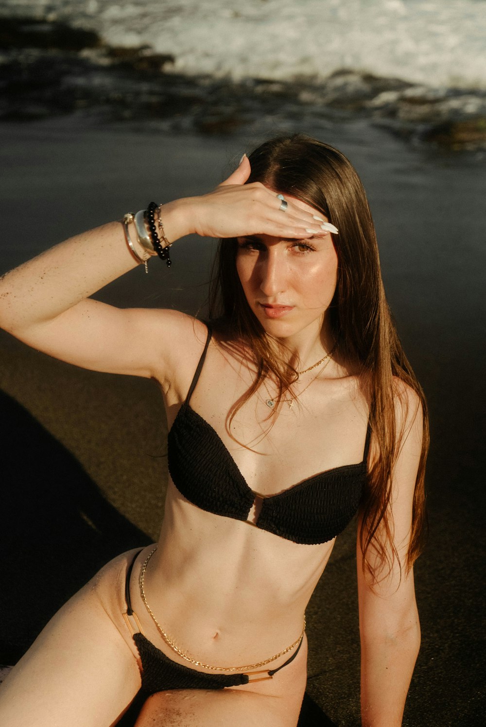 a woman in a bikini sitting on the beach