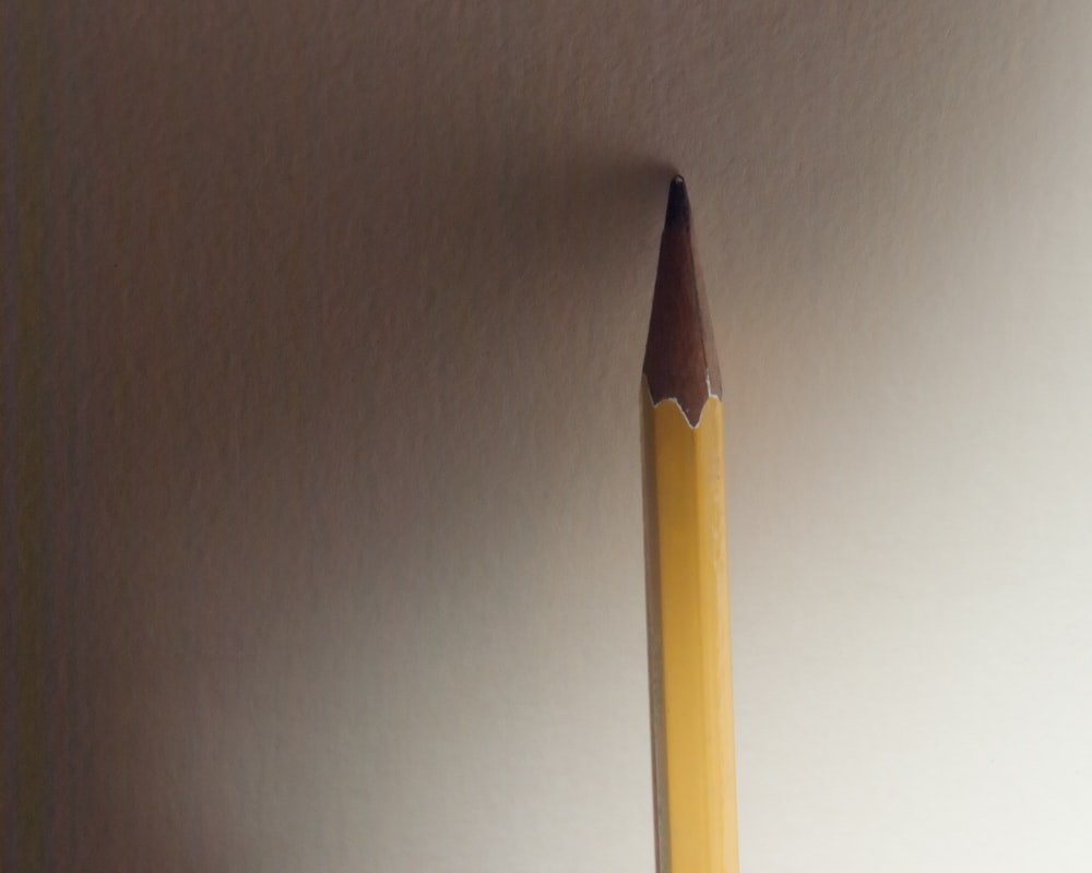 a pencil sticking out of the side of a wall