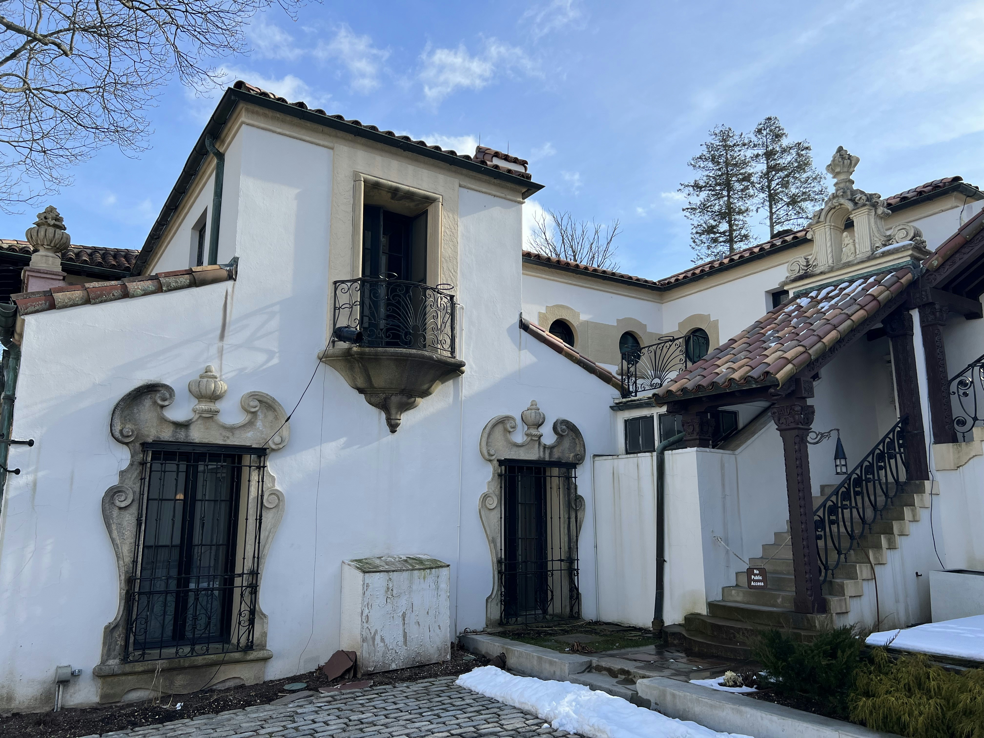 a white house with a balcony and a staircase