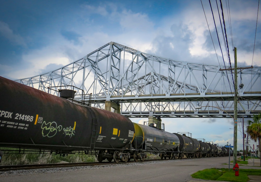 a train traveling down tracks under a bridge