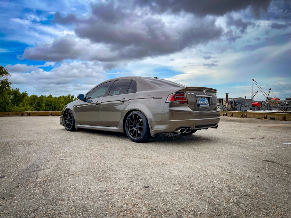 a silver car parked in a parking lot under a cloudy sky