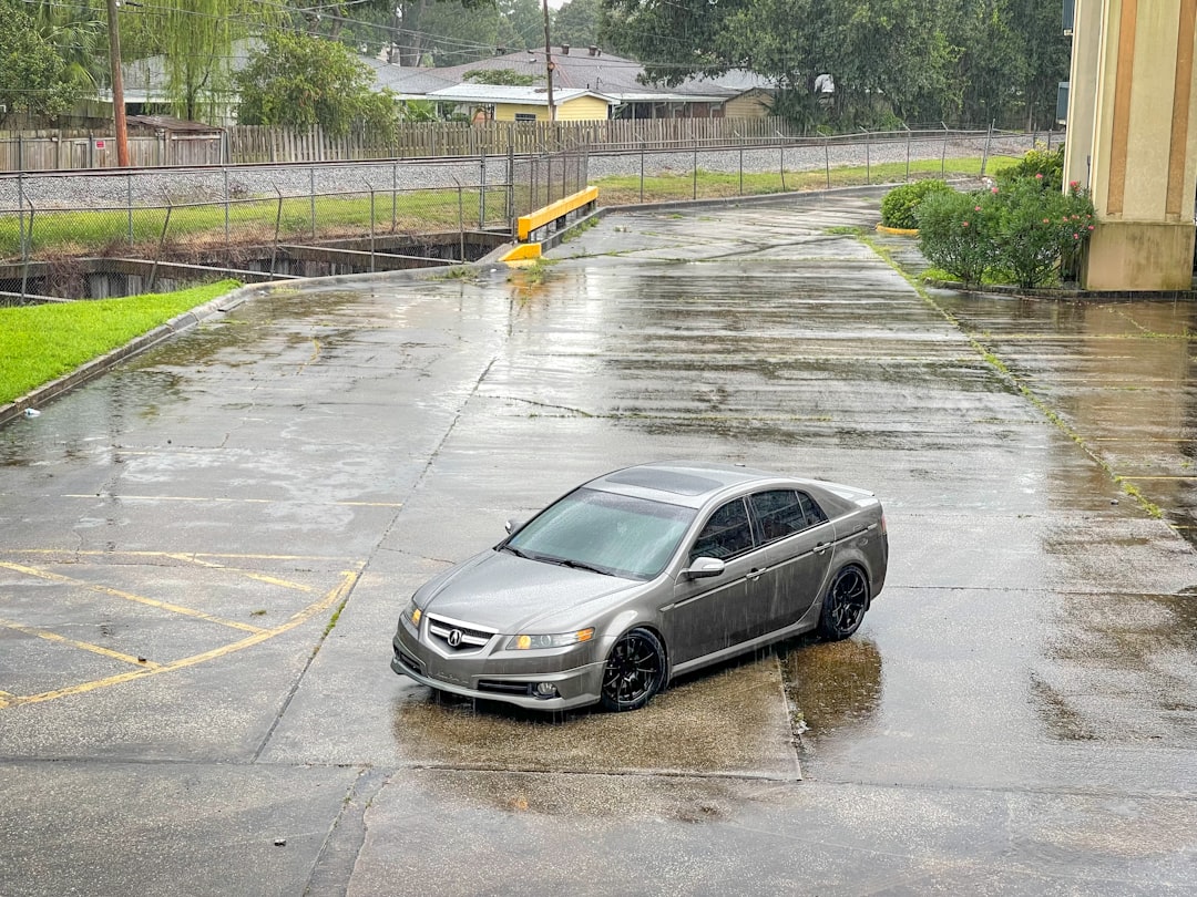 a car parked in a parking lot in the rain,