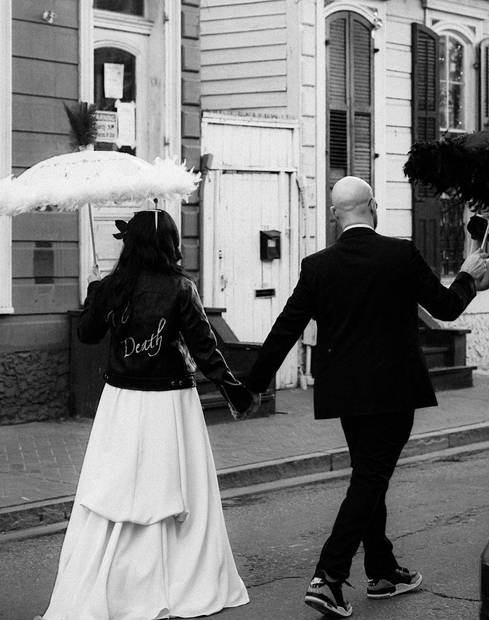 a man and woman walking down a street holding hands