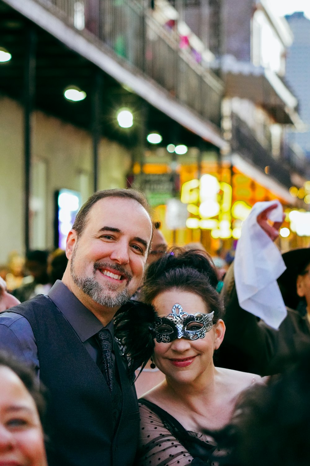 a man and woman pose for a picture in front of a crowd