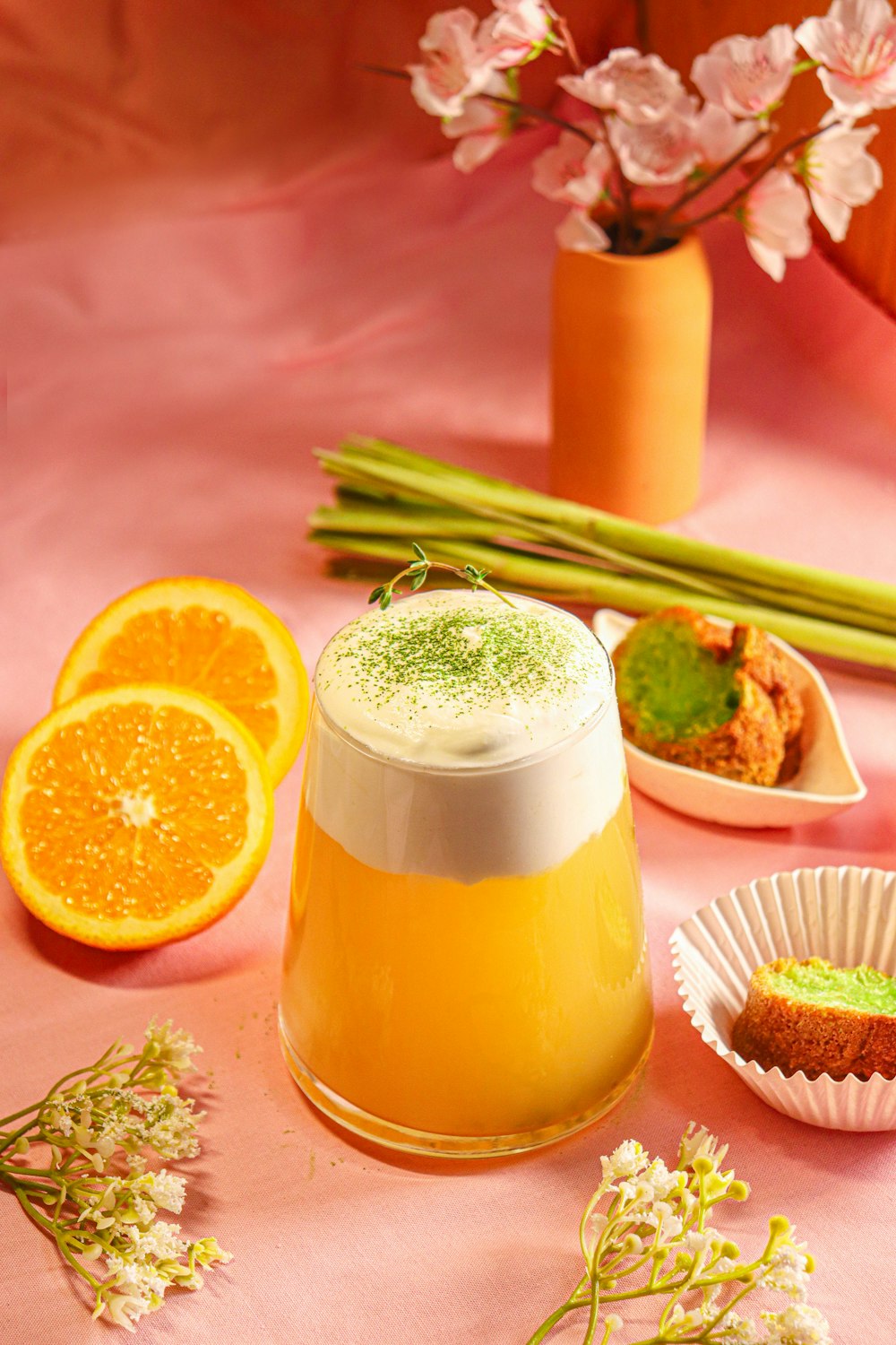 a table topped with oranges and a pitcher of liquid