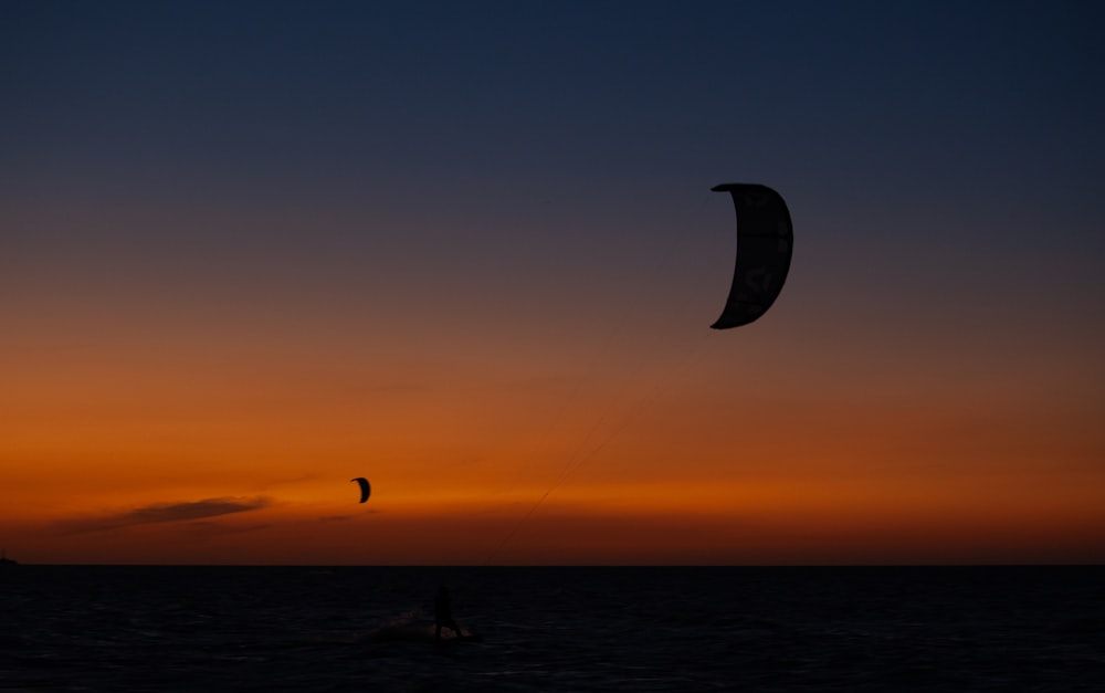 a person para sailing in the ocean at sunset