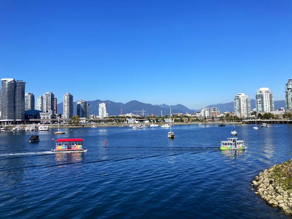 a body of water with boats in it and a city in the background