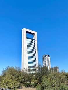 a tall white building with a blue sky in the background
