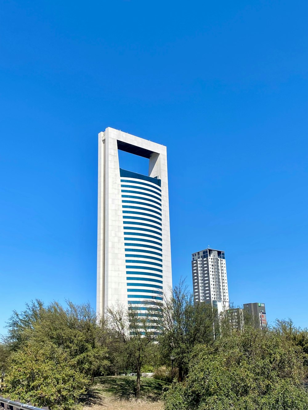 a tall white building with a blue sky in the background