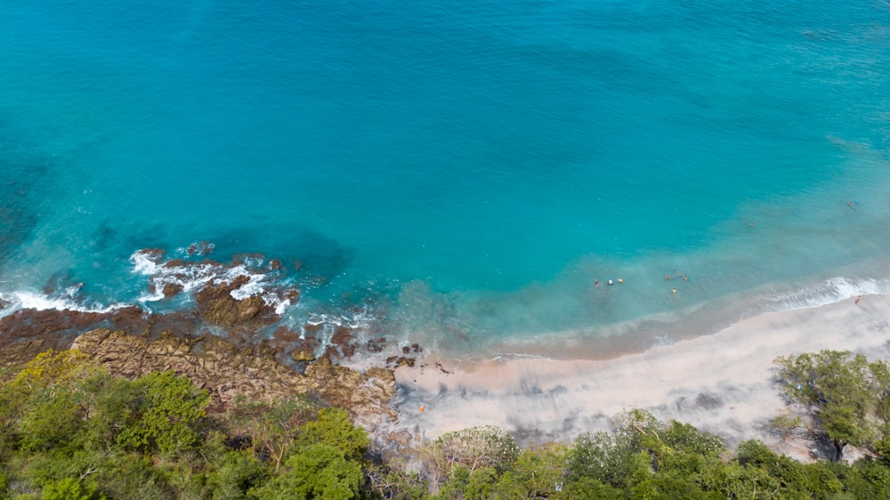 an aerial view of a beach with blue water