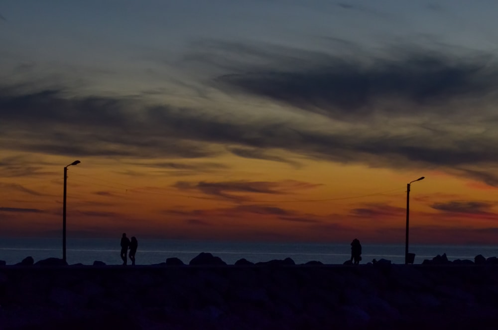 a couple of people standing on top of a beach