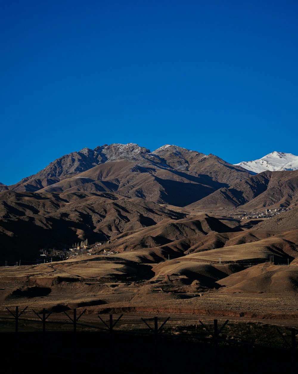 a mountain range with snow capped mountains in the background