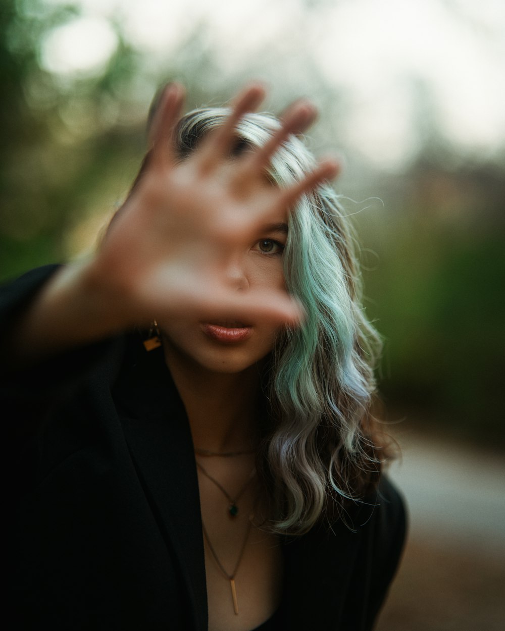 a woman with green hair is making a hand gesture