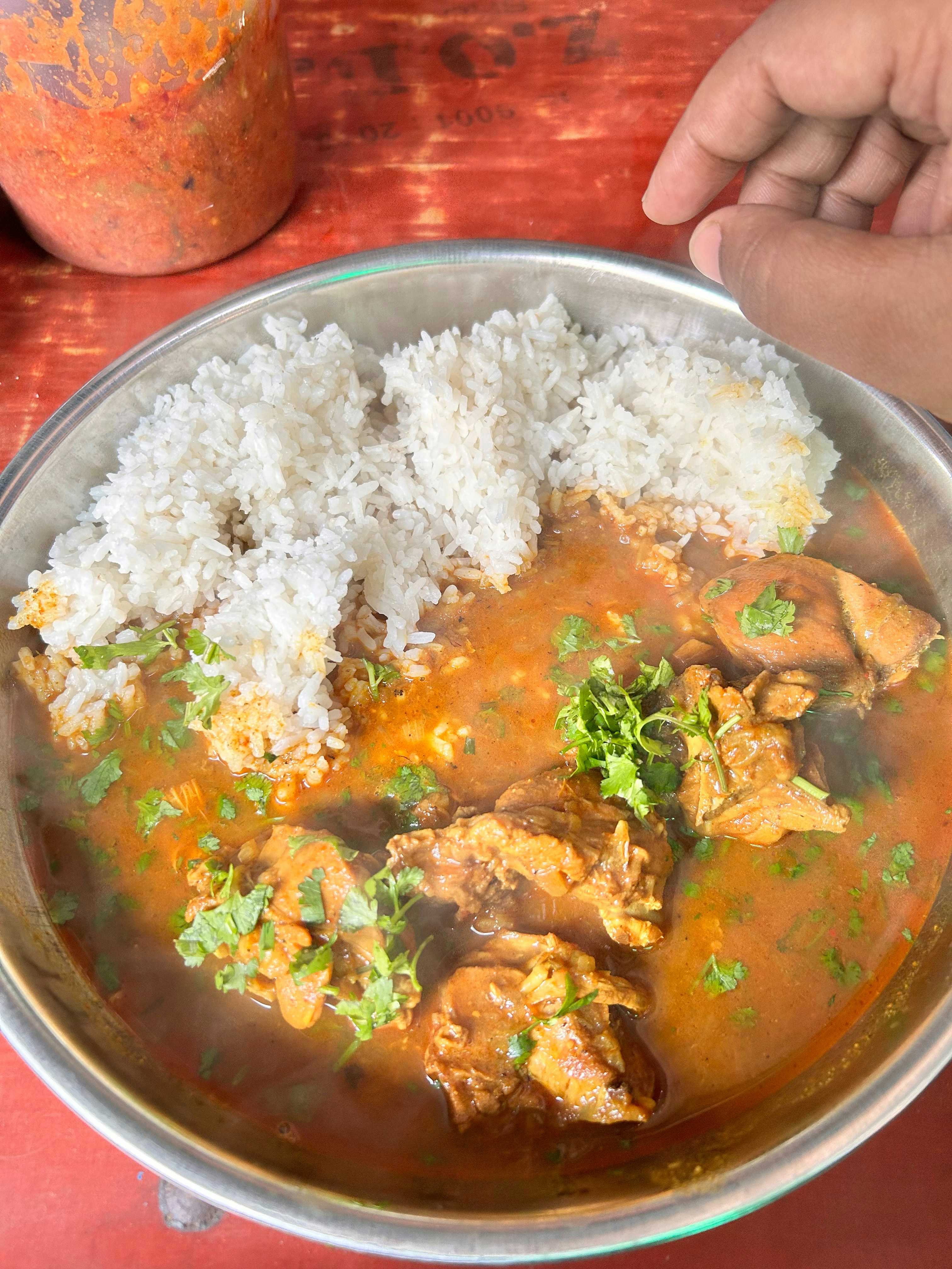 Spiced chicken curry in a clay bowl with coriander garnish