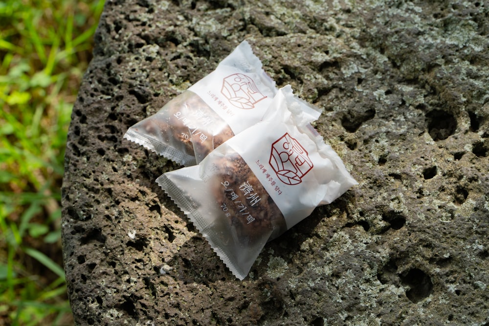 a couple of bags of food sitting on top of a rock