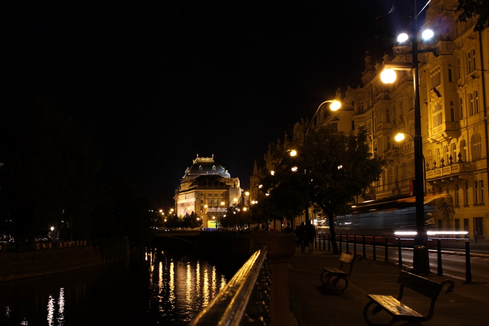 a city street at night with lights reflecting in the water