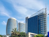 a tall building with a curved roof next to other buildings