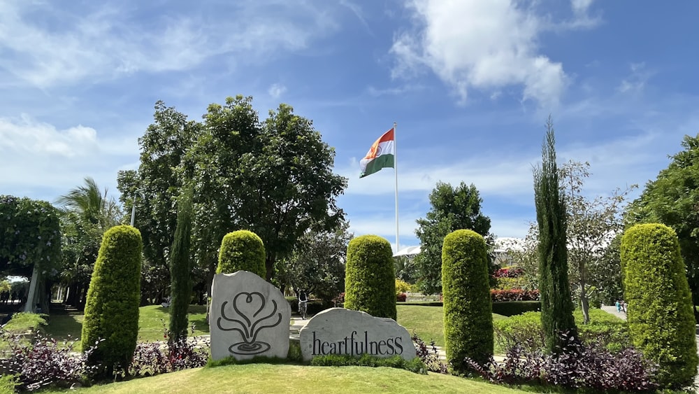 a sign in front of some trees and bushes