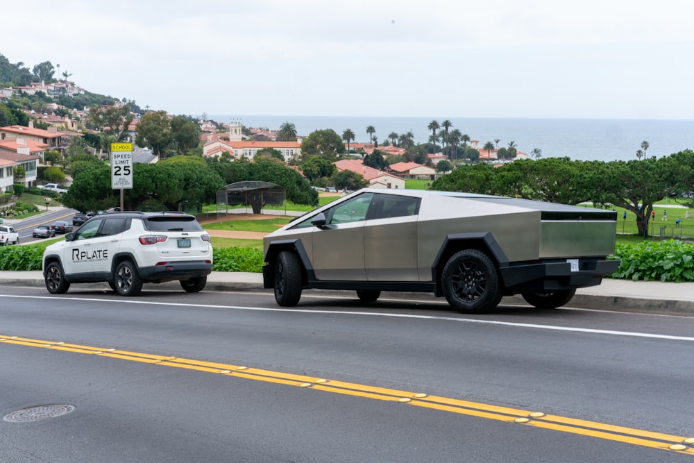a futuristic car driving down a street next to a white suv
