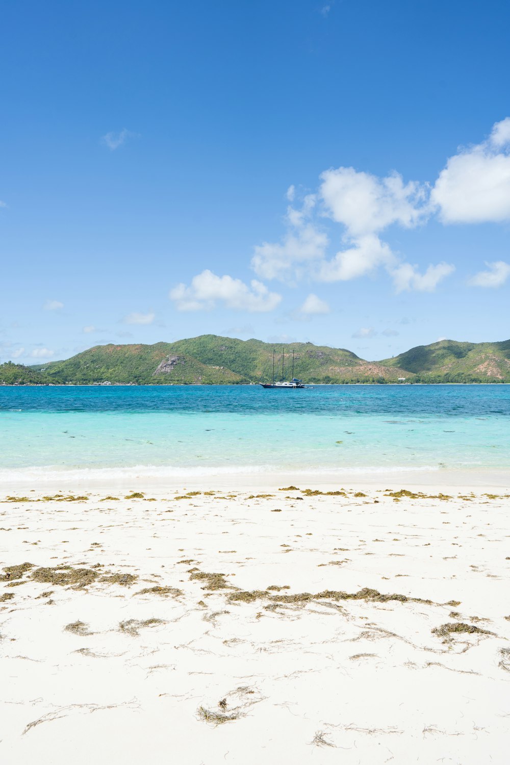 a sandy beach with a boat in the distance