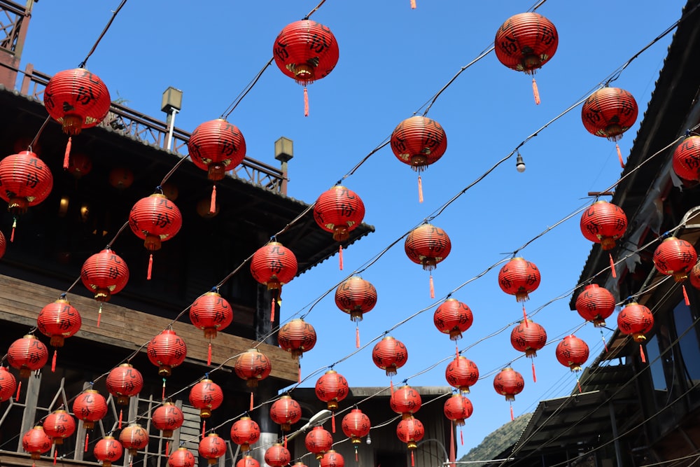 a bunch of red lanterns hanging from a wire