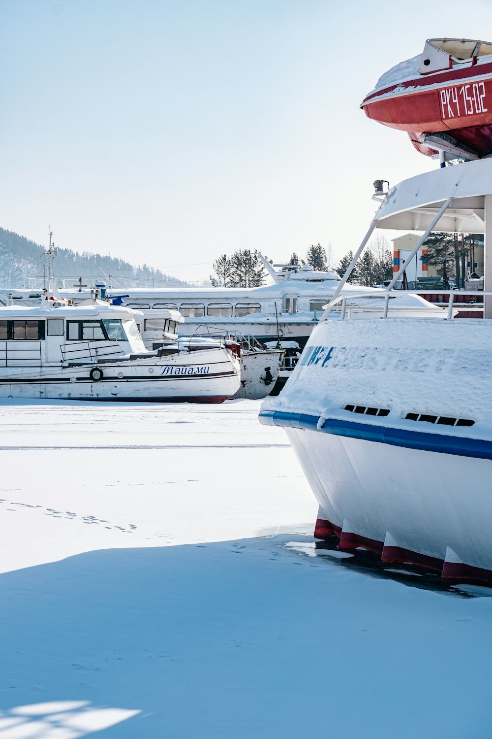 a large white boat sitting on top of a snow covered field