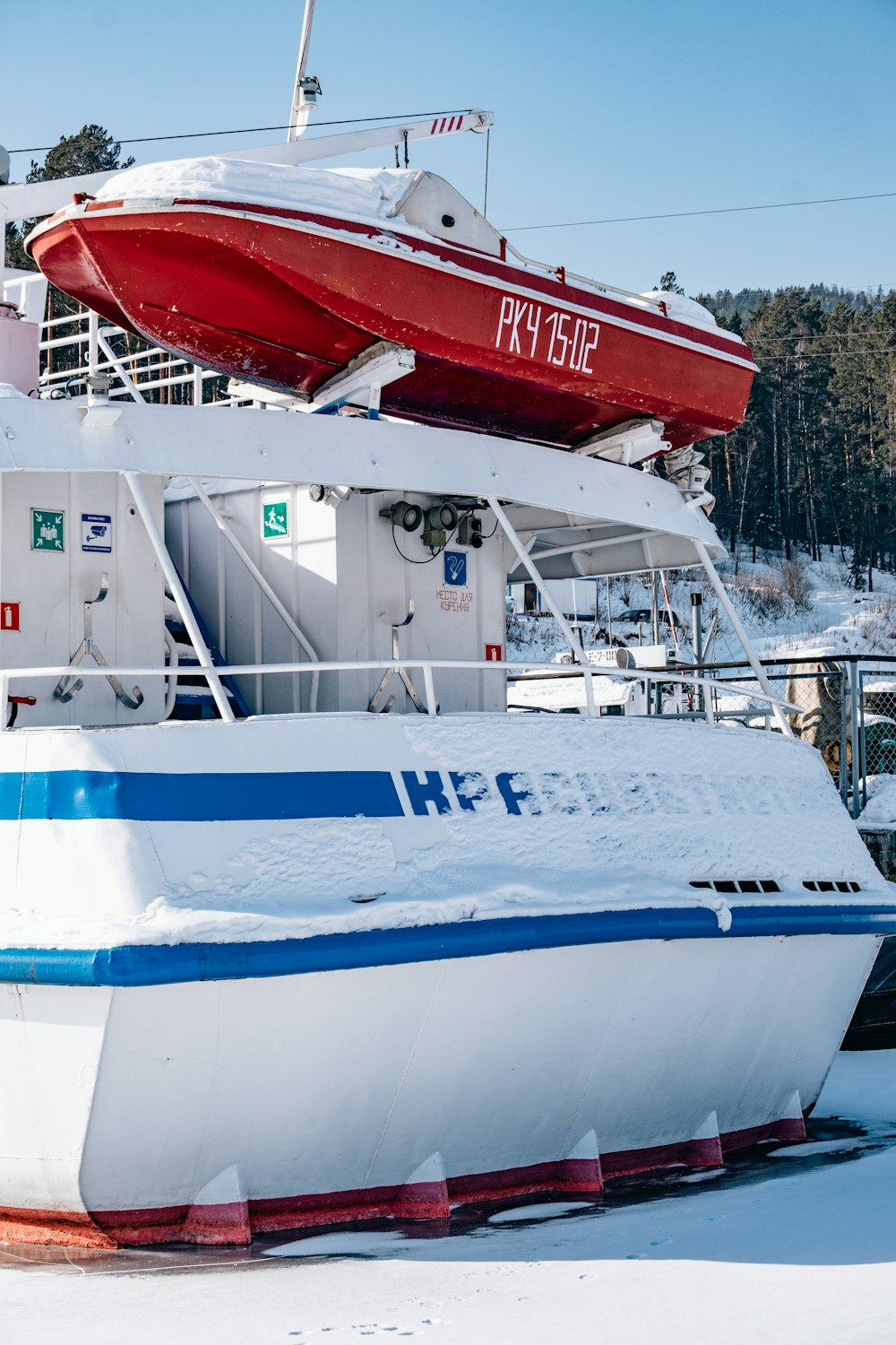 ein rot-weißes Boot, das auf schneebedecktem Boden sitzt