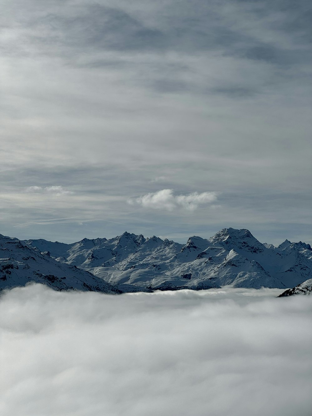 a view of a mountain range covered in clouds