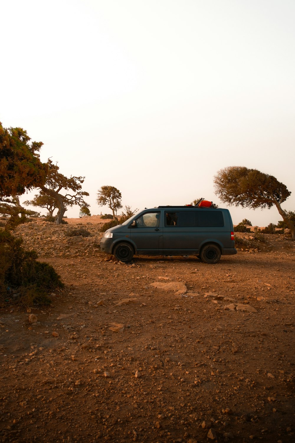 a van parked in the middle of a dirt field