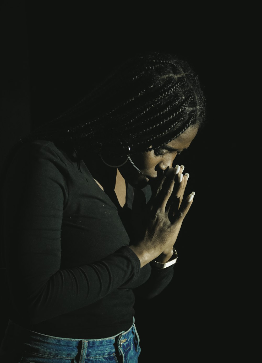 a woman in a black shirt is holding her hands together