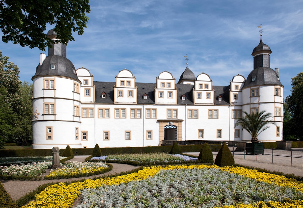 a large white building with a garden in front of it