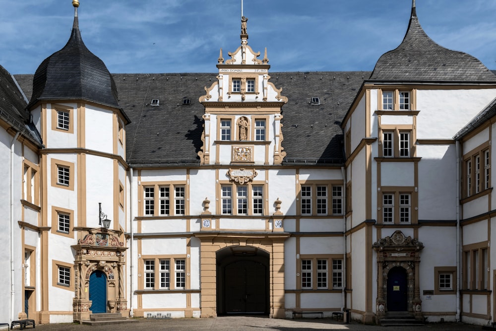 a large white and brown building with a blue door