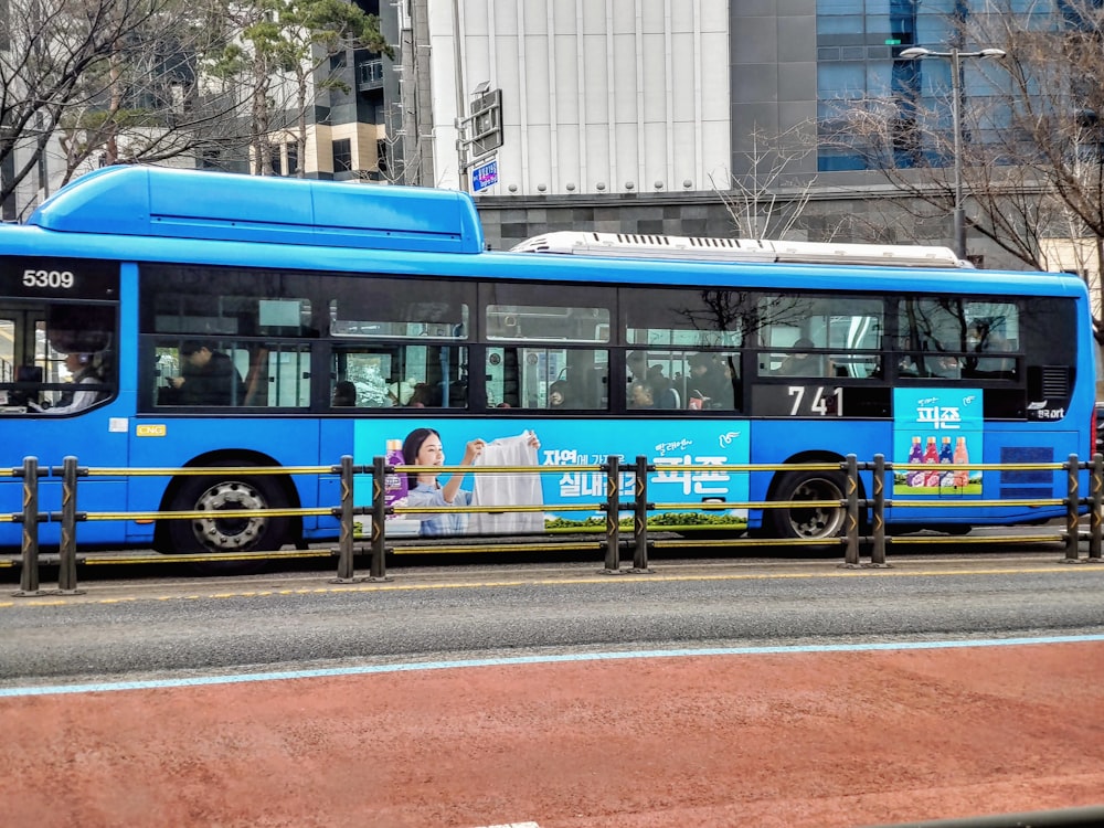 a blue bus parked on the side of the road