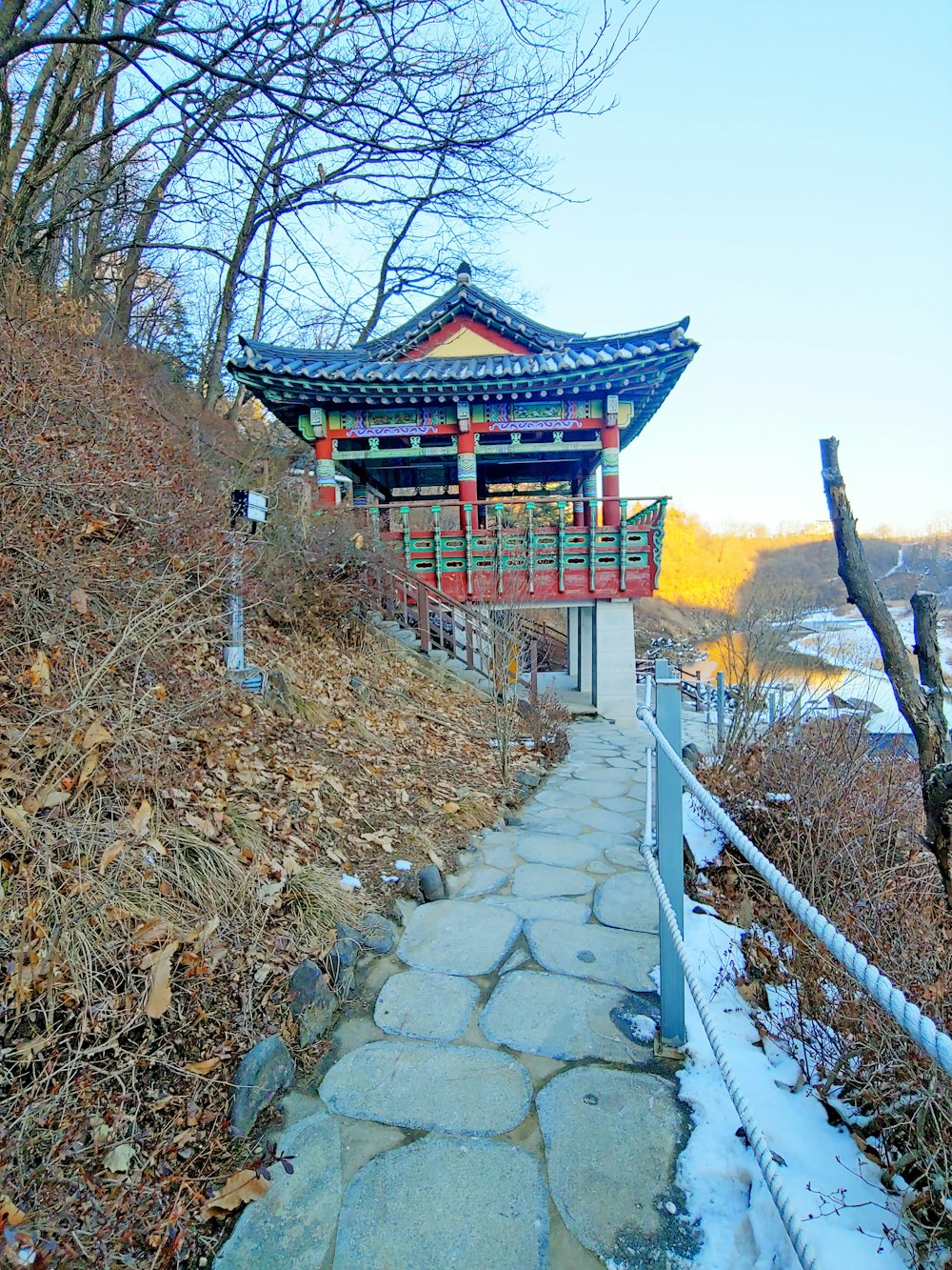 a stone path leading to a pagoda on a hill
