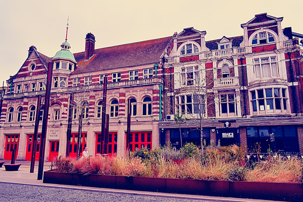 a large building with a lot of windows and plants in front of it