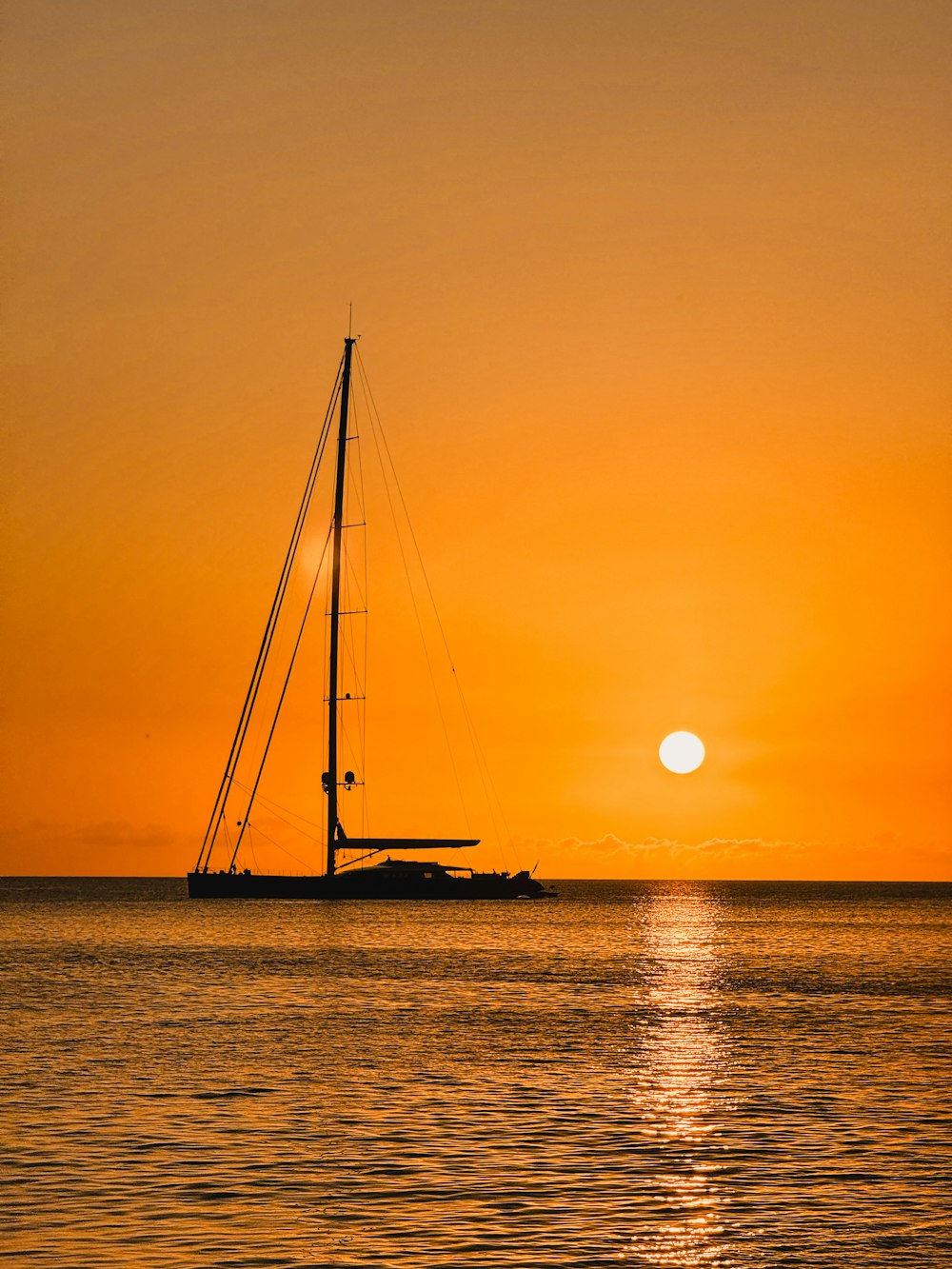 a sailboat in the ocean at sunset