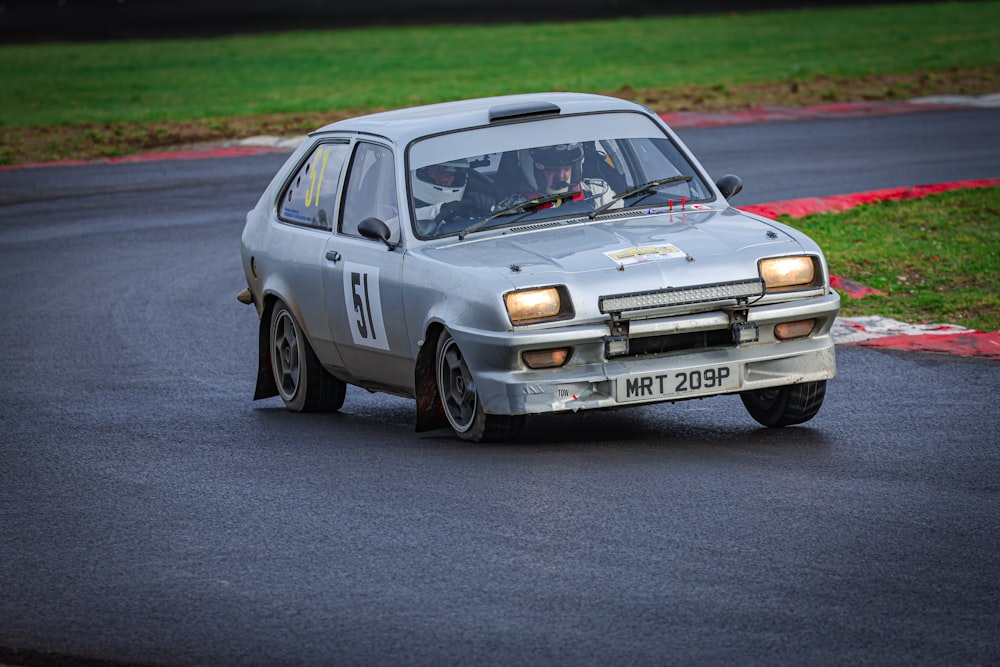 a small car driving down a race track