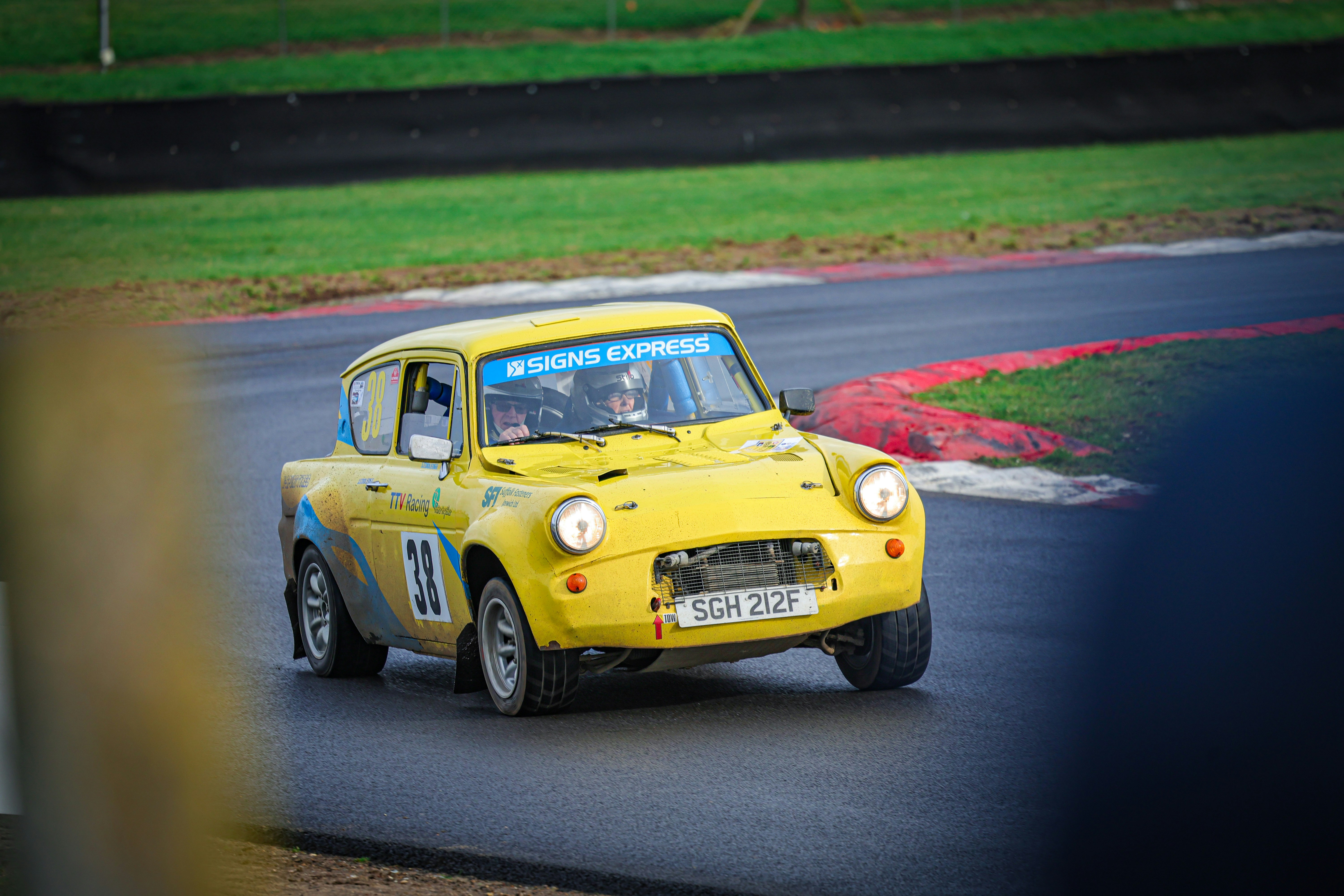 a yellow car driving down a race track