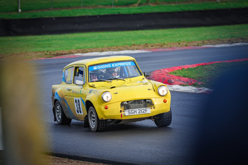 a yellow car driving down a race track