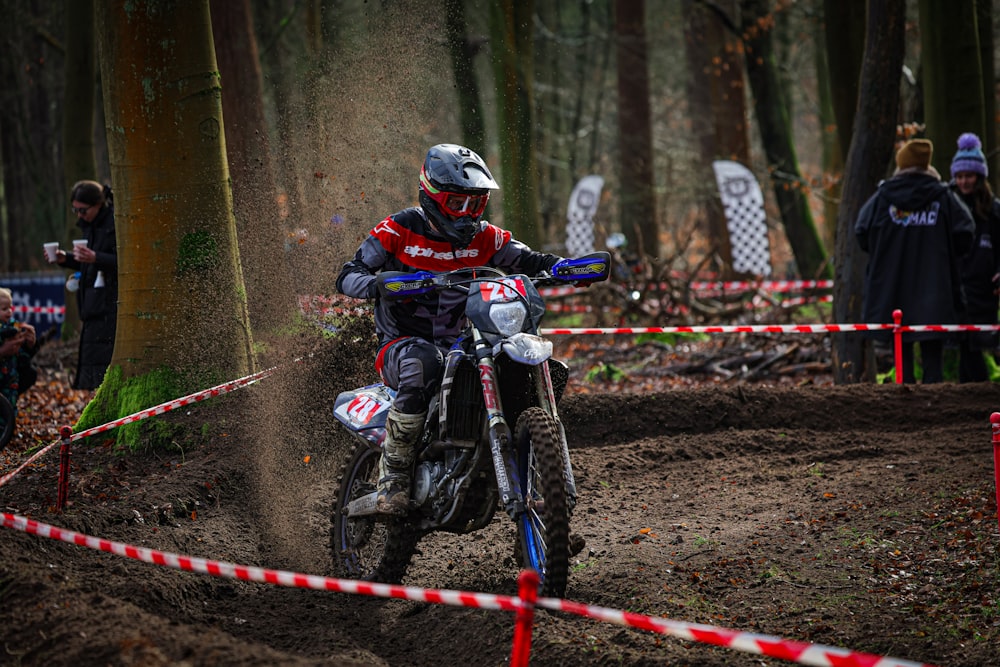 a man riding a dirt bike through a forest