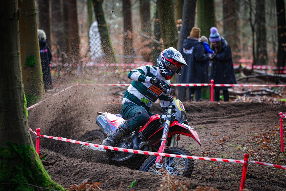 a man riding a dirt bike through a forest