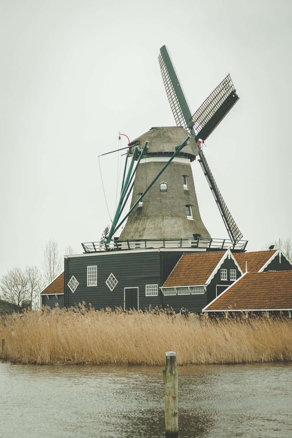 a windmill sitting next to a body of water