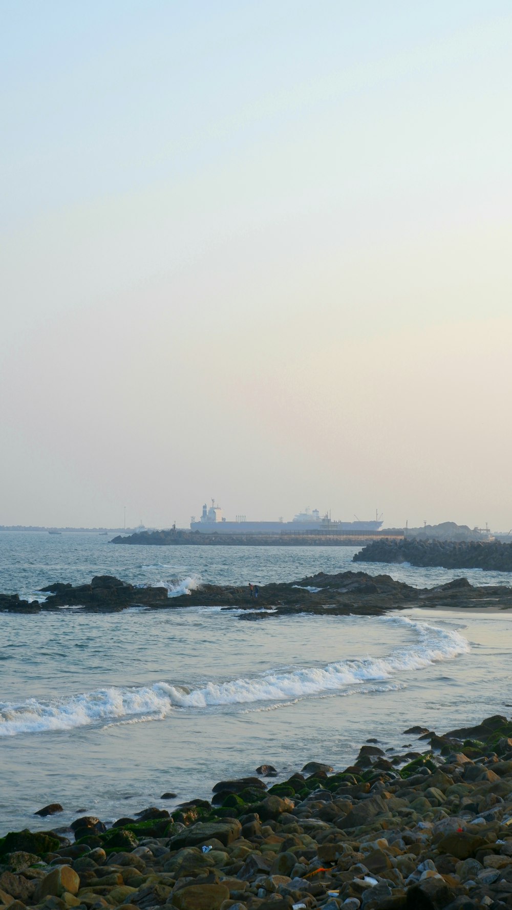 a large body of water sitting next to a rocky beach