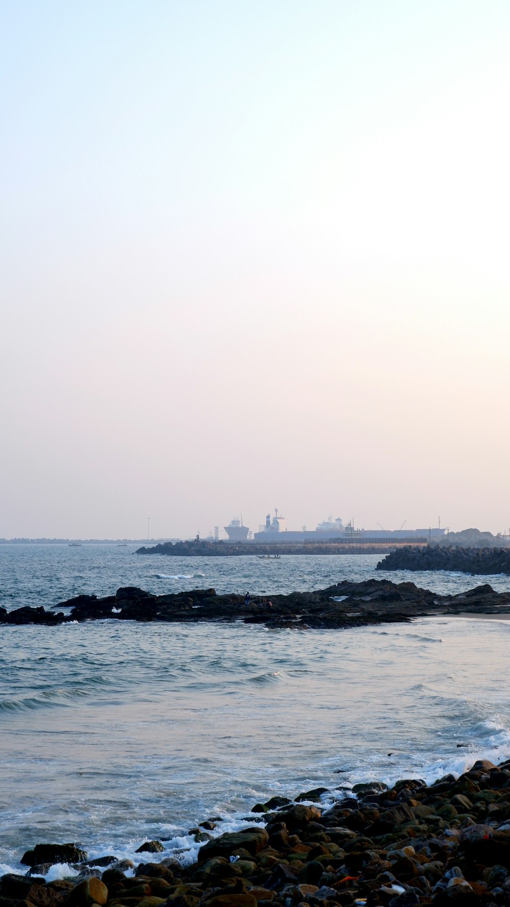 a large body of water sitting next to a rocky shore