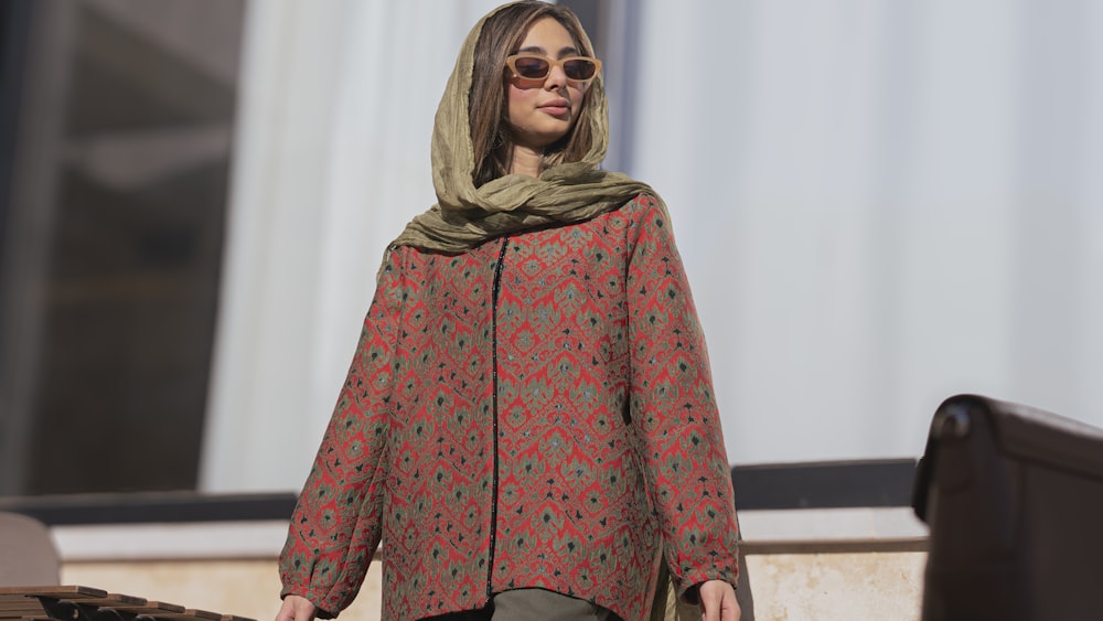 a woman wearing a red and green jacket and scarf