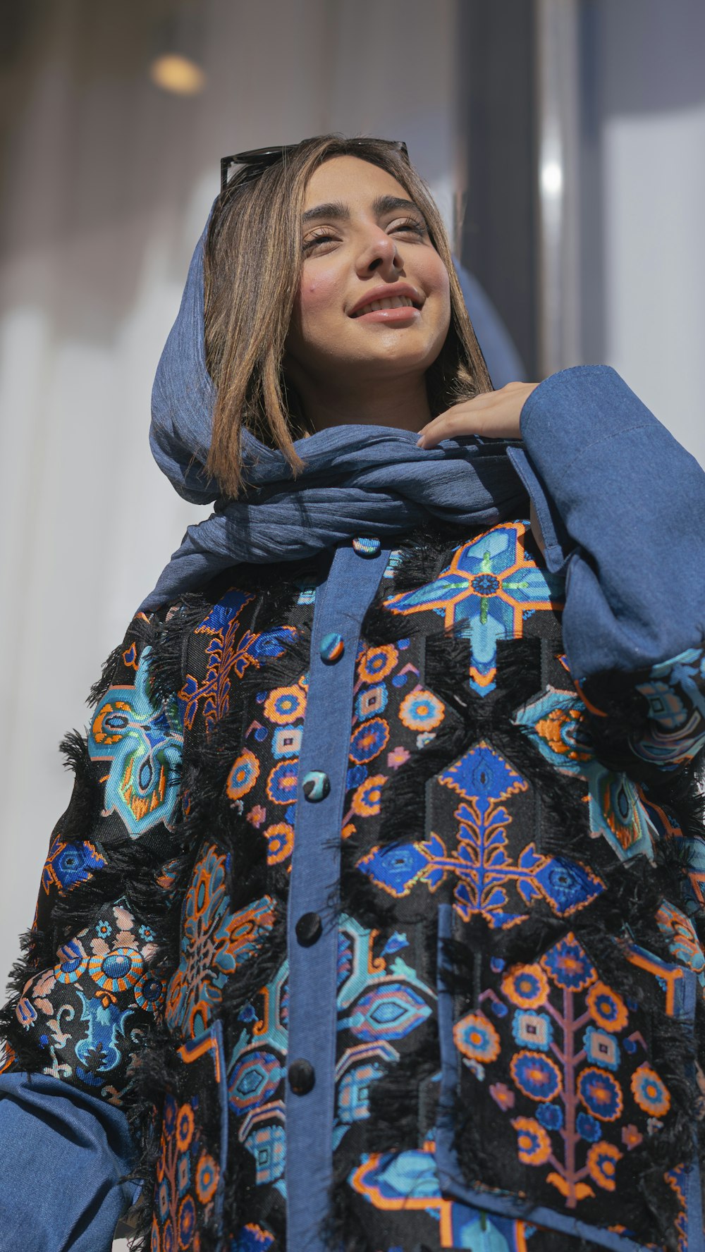 a woman wearing a blue jacket and a blue scarf